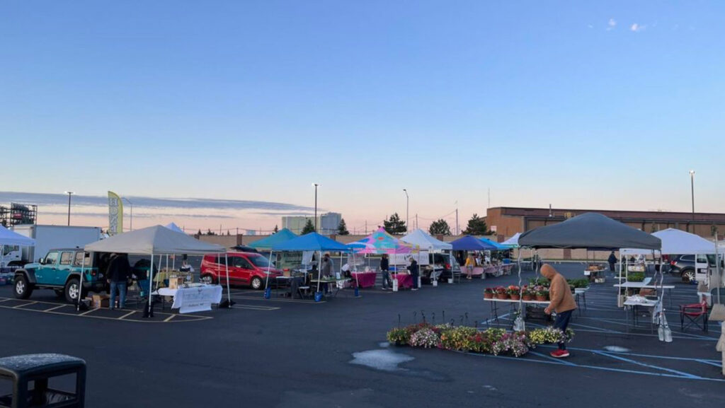 Photo of tents and people in parking lot for Midland farmer’s market.